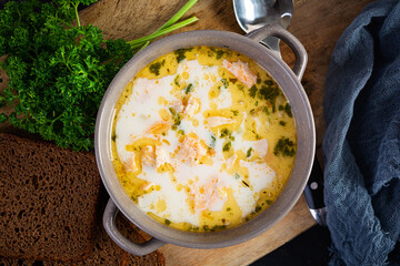 Creamy salmon soup with potato, carrot, leek and bread. Lohikeitto soup, finnish cuisine. Top view