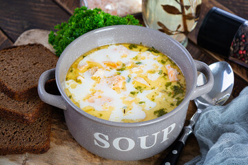 Creamy salmon soup with potato, carrot, leek and bread. Lohikeitto soup, finnish cuisine