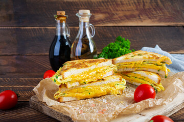 Roasted French toast with ham, egg, herbs and cheese cheddar. Delicious grilled breakfast sandwich