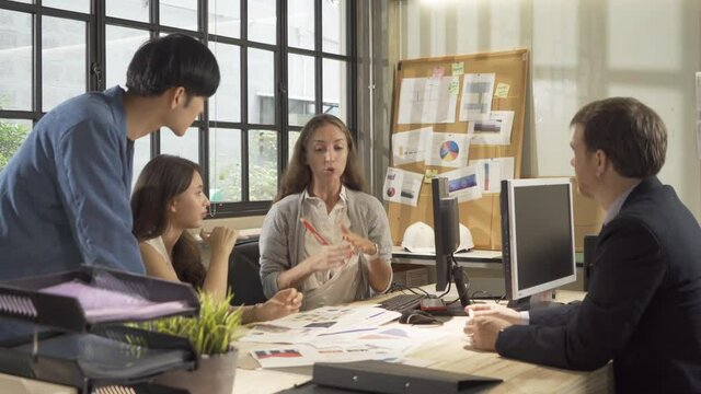 A group of multi ethnic business team talk, communicate, discuss, and work in meeting room in office, present ideas with a computer technology device to colleagues. People lifestyle. Corporation