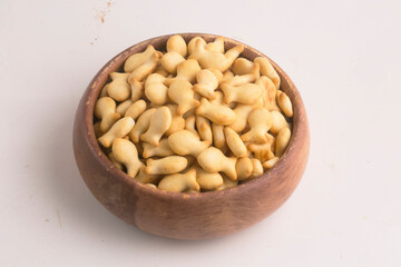 bowl with fish crackers on grey background