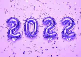 2022 violet balloons on pink background with glitters. Festive new year background concept.