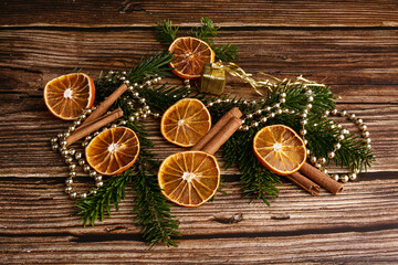 Wooden table with dried orange slices and cinnamon