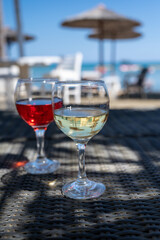 Drinking of cold rose and white wines in lounge bar on sunny sandy beach with blue sea water on background