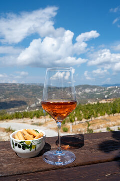 Wine industry of Cyprus island, tasting of rose dry wine on winery with view on vineyards and south slopes of Troodos mountain range.