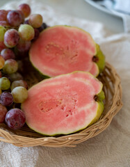 Fresh ripe pink guava tropical fruit and sweet table grapes ready to eat