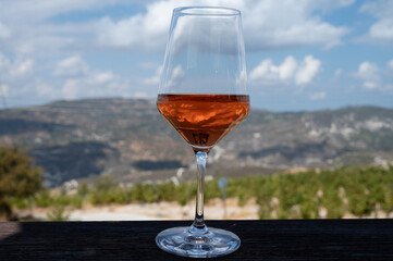 Wine industry of Cyprus island, tasting of rose dry wine on winery with view on vineyards and south slopes of Troodos mountain range.