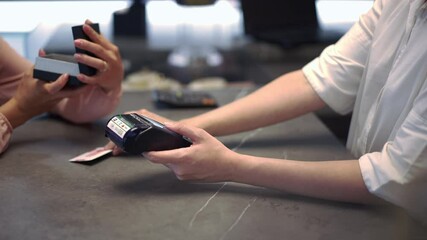 Unrecognizable woman using POS terminal cashless payment serving rich customer admiring jewellery box in hands. Caucasian seller making transaction with credit card serving client in slow motion