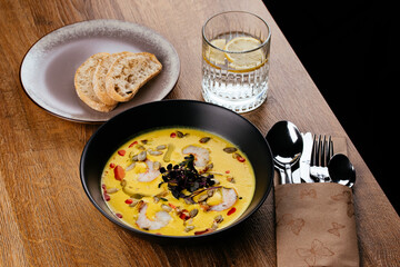 corn soup with shrimp in a black plate