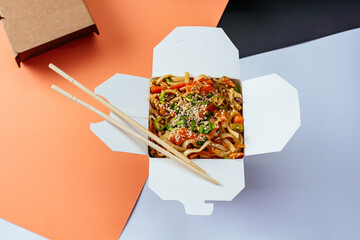 chinese rice noodles with chicken and vegetables in a takeaway box