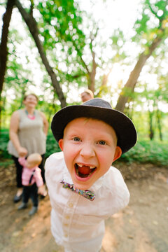 Closeup portrait of a boy laughing with his family in the background