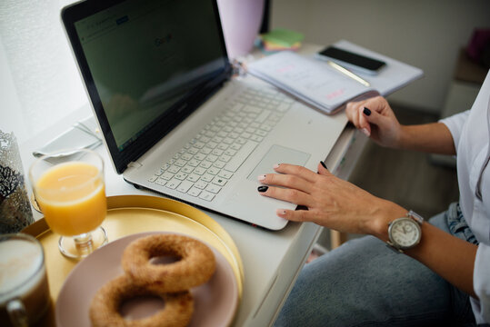 Close-up of a woman using a laptop touchpad.