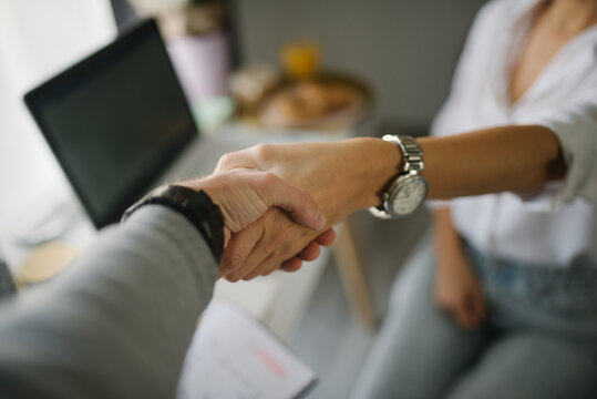 Close-up of a woman shaking hands with a man.