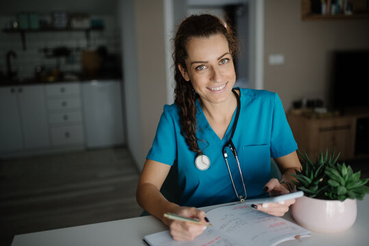 Veterinarian holding a pen and a phone in her office.
