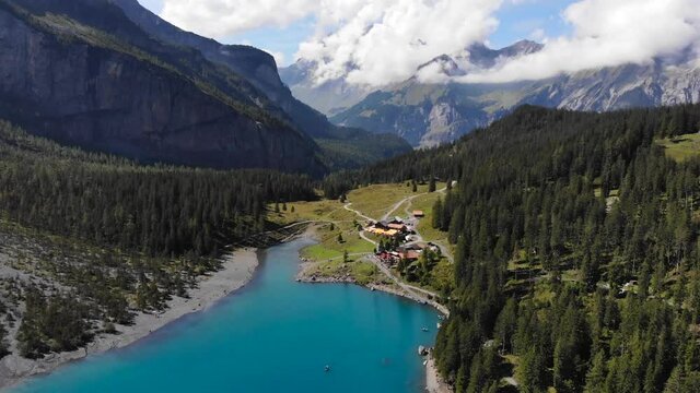 Aerial: Oeschinen lake among rocky mountains in the Alps