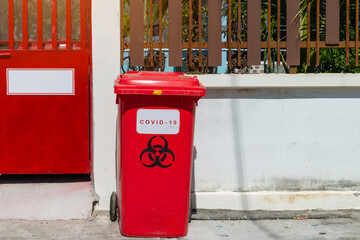 Biological Hazard Infecting Red Trash biohazard symbol sign, Used infectious masks and medical glove in the trash bin,infectious waste, prevented virus covid-19 by separating infected waste.