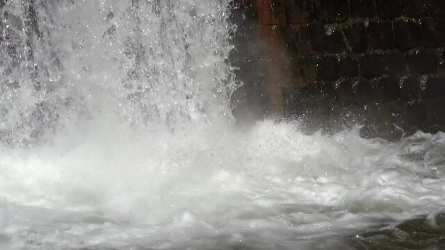 Water flowing into a water storage reservoir during autumn heavy rains, flood pervention, slow motion