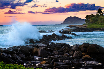 Ocean waves hit the shore at sunset in Hawaii 