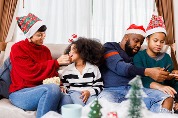 Happy family has fun sitting together on the sofa at home. cheerful young family with children laughing. African American family