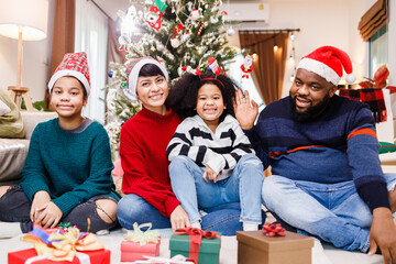 African American family in Christmas theme. Happy African American family of four bonding sitting on the floor together with Christmas decorations in the living room.