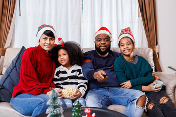 African American family in Christmas theme. Happy family has fun sitting together on the sofa at home. cheerful young family with children laughing. African American family