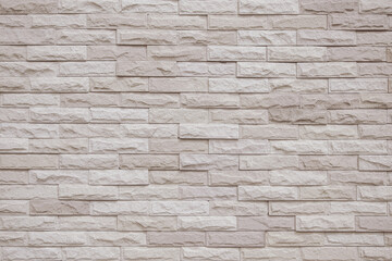 Cream and beige brick wall texture background. Brickwork and stonework flooring interior rock old pattern clean concrete grid uneven bricks office design.