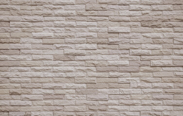 Cream and beige brick wall texture background. Brickwork and stonework flooring interior rock old pattern clean concrete grid uneven bricks office design.