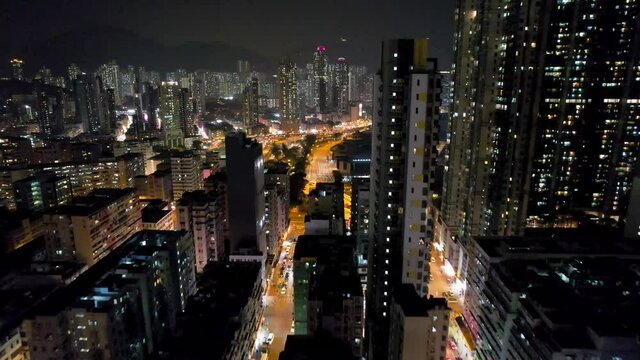 Aerial night footage of the downtown Kowloon, Hong Kong, modern buildings and highways