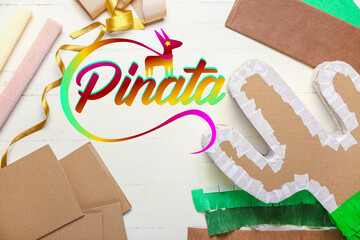 Preparation of Mexican pinata on white wooden background