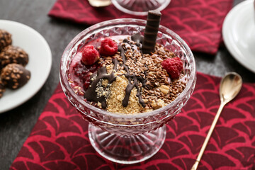 Tasty dessert with flax seeds and yoghurt in glass on dark background