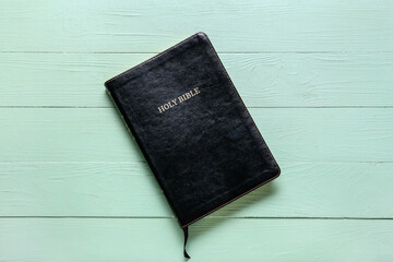 Black Holy Bible on green wooden background