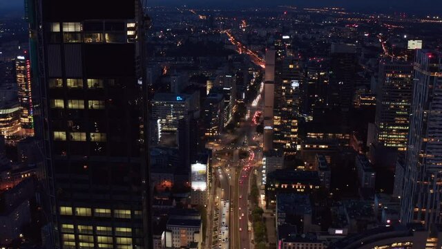 Tilt down shot heavy traffic in wide multilane street. Aerial view of downtown at night. Warsaw, Poland