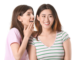Young gossiping women on white background
