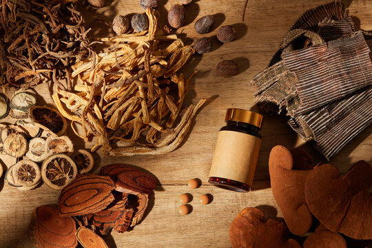 Traditional chinese medicine with herb and spices in brown wooden background and medicine jar , for medicine advertising , photography traditional medicine content