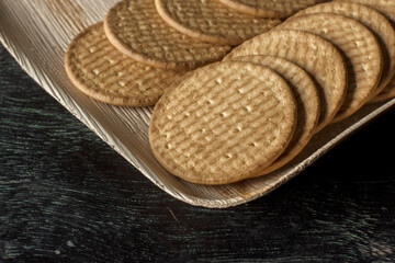 A plate full of English marie biscuits with dark background. Selective focus.