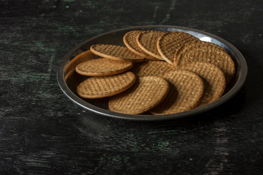 A steel plate full of English marie biscuits with dark background. Selective focus.