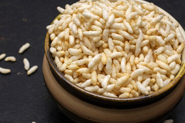 A bowl full of organic puffed rice with dark background. Selective focus.