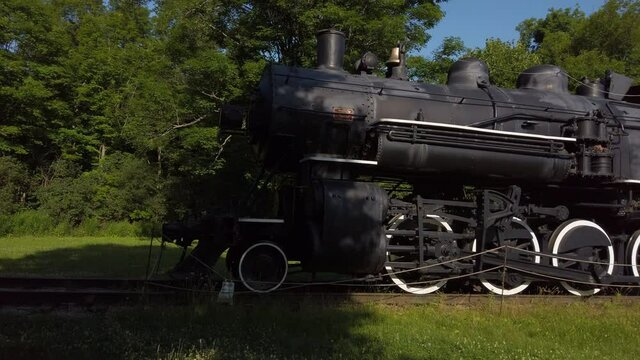 Wide panning shot from train tracks over to an old steam locomotive