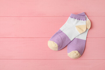 Obraz na płótnie Canvas Pair of socks on pink wooden background