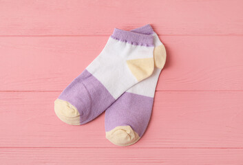 Obraz na płótnie Canvas Pair of socks on pink wooden background