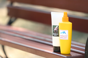Mosquito repellent spray and cream on bench outdoors - obrazy, fototapety, plakaty