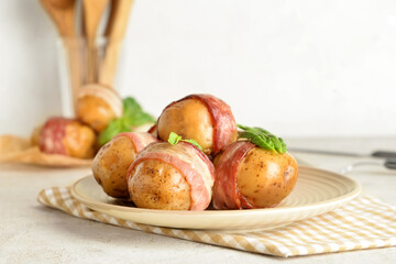 Naklejka na ściany i meble Plate of delicious baked potatoes with bacon on light background