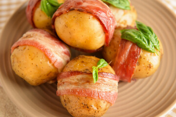 Plate of delicious baked potatoes with bacon on table, closeup