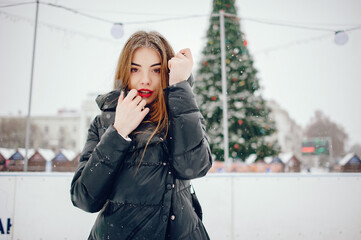 Fototapeta premium Young girl in a white sweater standing in a winter park