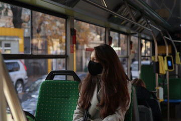 European woman passenger wearing a face mask when traveling by bus