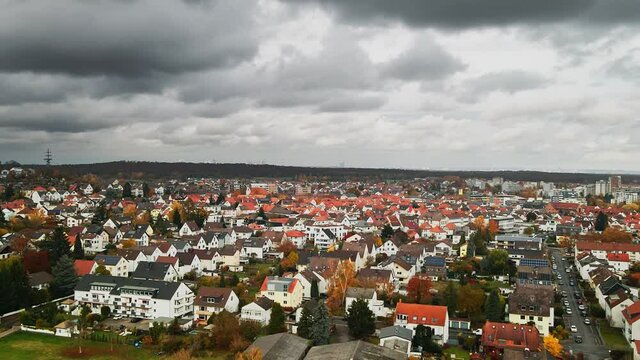 Aerial, residential suburb with traditional tile red roofs in Europe, dark cloudy day