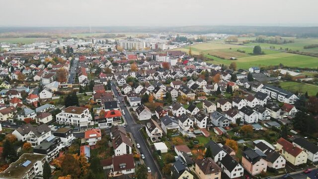 Aerial, residential housing in Dietzenbach, Germany. Rural agriculture farm town, dolly in pan parallax