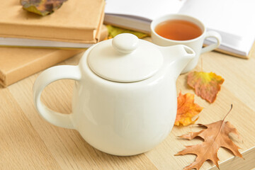 Tea pot and autumn leaves on table