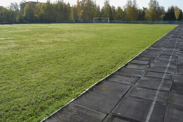 Running track and field at a public stadium against the backdrop of autumn trees.