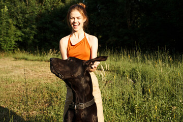 woman outdoors in the field with dog friendship playing